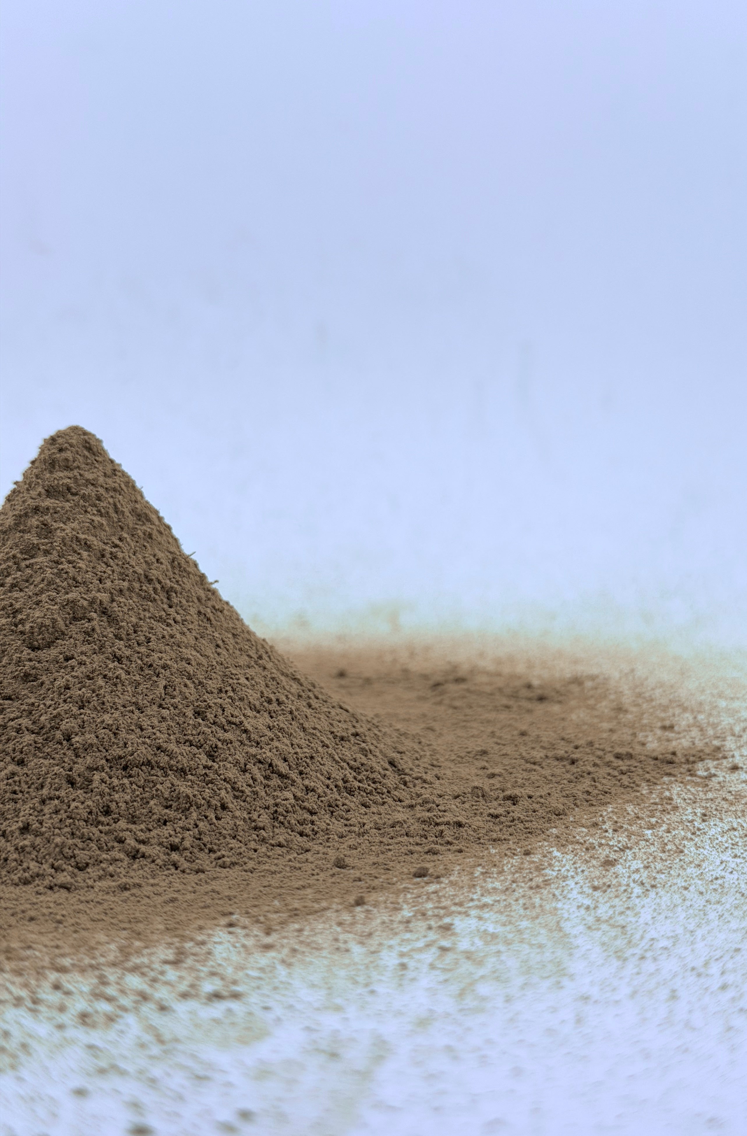 Hojicha powder in a pyramid shape on a white surface