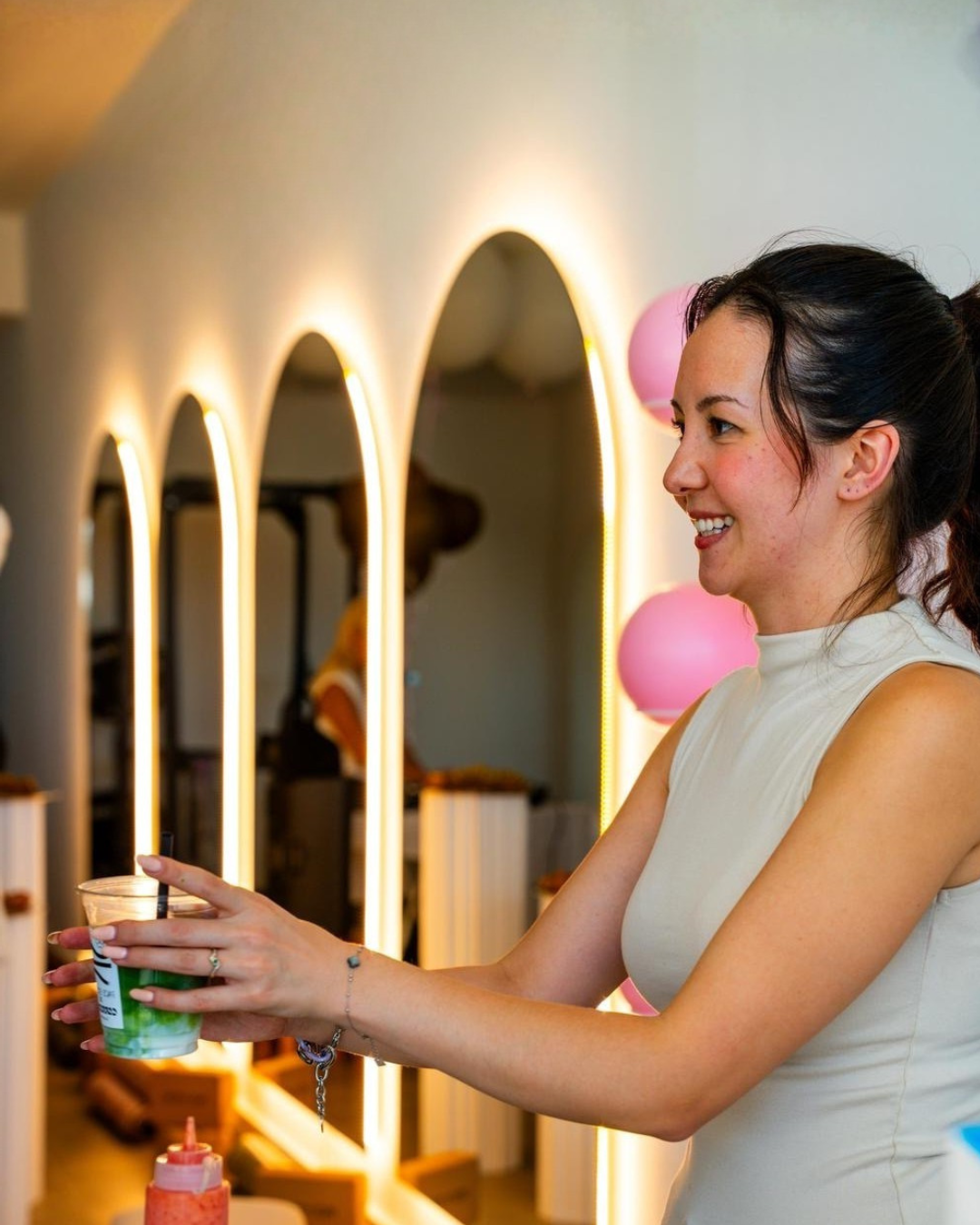 Smiling young woman serving a matcha latte at an event